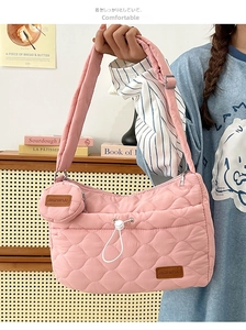 Détail du sac à épaule en nylon matelassé rose avec cordon de serrage et petite pochette