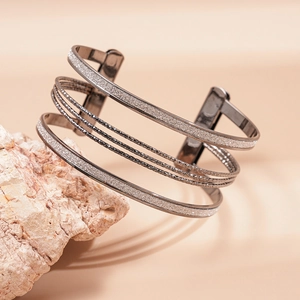 Macro detail of multilayer geometric gunmetal cuff bracelet with hammered textures on stone