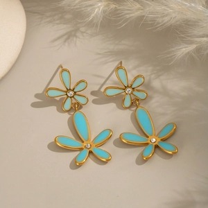 Close-up of gold-plated flower earrings with blue enamel and small diamonds