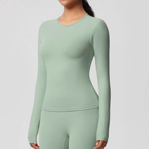 Détail de haut de yoga vert sauge à manches longues avec tissu de sport hautement élastique