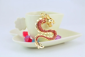 Vue détaillée d'un porte-clés dragon doré orné de strass rouges et d'une perle centrale