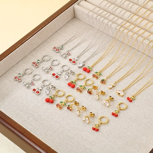 Détail d'un ensemble de bijoux cerise et cœur en finitions argentée et dorée
