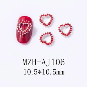Macro detail of red heart metal nail charms with 10.5mm rhinestone embellishments