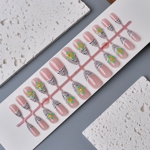 Almond French press-on nails with zebra stripes, 3D green petals and rhinestones
