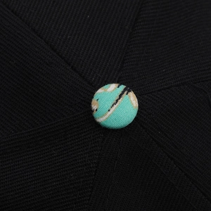 Macro view of the mint green printed fabric button on a black hip-hop sun hat