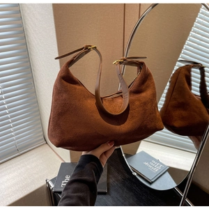 Detailed texture of dark brown suede hobo bag with adjustable leather shoulder strap