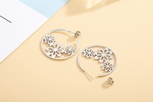 Detail showing high-quality polished silver hollow flower hoop earrings with metal backs