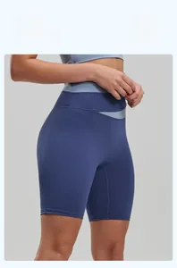 Detail of high-waisted yoga shorts showing two-tone blue color-block design and matte texture