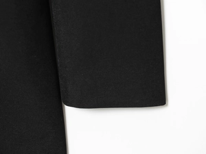 Macro shot of high-quality black twill fabric texture on a women's blazer sleeve