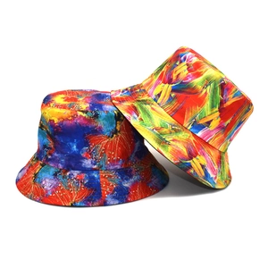 Detail of two reversible tie-dye bucket hats with artistic splash and starry sky patterns