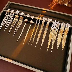 Macro shot of assorted gold tassel earrings with zircon stars and hearts on display