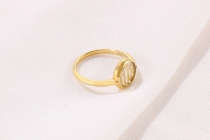 Macro view of gold stainless steel ring featuring a hollow paw print design and 316L hallmark