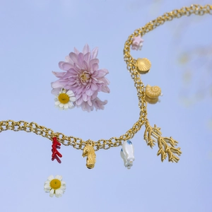Macro shot of gold ocean necklace with coral, seahorse, and starfish charms