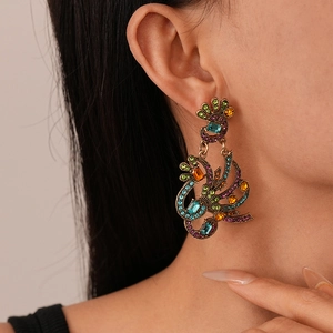 Close-up of vintage peacock earrings with multi-color crystals and bronze finish