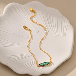 Bracciale in rame placcato oro 18K con pietra di vetro verde smeraldo su vassoio