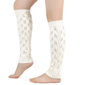 Detail of white knit leg warmers with hollow leaf pattern and ribbed cuffs for women