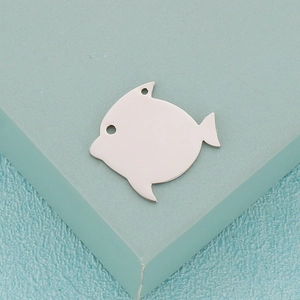 Macro shot of silver fish-shaped stainless steel pendant with dual connection holes