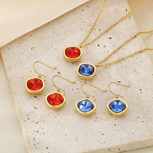Detail of 18k gold plated necklace and earrings set with red and blue zircon stones
