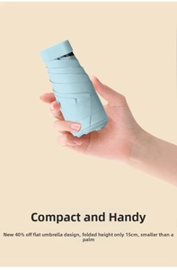 Compact 15cm light blue flat folding umbrella held in hand for size comparison