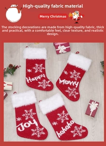 Close-up of four red knitted Christmas stockings with snowflake patterns and festive text