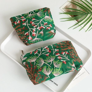 Vue détaillée de deux trousses à cosmétiques à motifs floraux verts sur un plateau