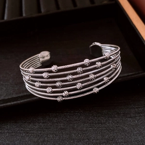 Close-up of silver multilayer beaded cuff bracelet with six rows of spiral metal wires