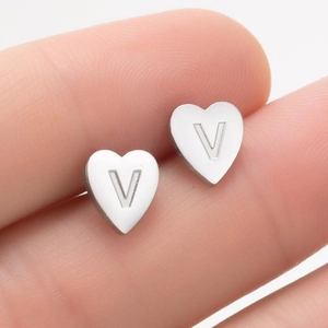 Vue macro d'une boucle d'oreille cœur en acier inoxydable avec la lettre V gravée