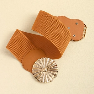 Close-up of a camel elastic waist belt with a golden round sunburst metal buckle