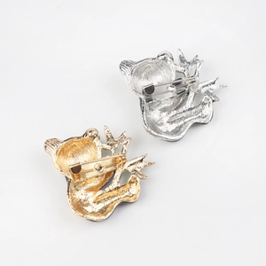 Detail view of gold and silver koala brooch showing secure safety pin back closure