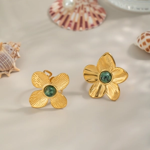 Bague vintage dorée fleur avec turquoise verte sur un décor naturel de coquillages
