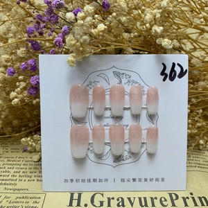 Detail of glossy pink to milky white gradient press-on nails on display card