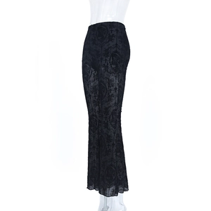 Detail of sheer black gothic mesh trousers with baroque cross patterns and flared hem