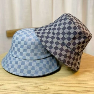 Detail of blue and black denim checkerboard bucket hats on a wooden surface