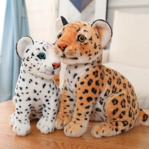 Close-up of cute snow leopard and yellow leopard plush toys on a wooden table