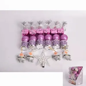 Close-up of pink and purple Christmas ornaments with silver tree topper and festive box
