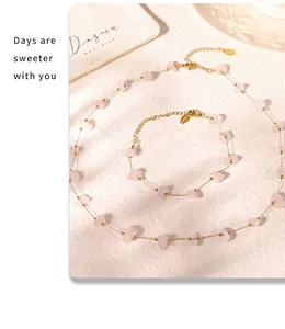 Macro detail of gold stainless steel chain set with natural pink stones and brand pouch