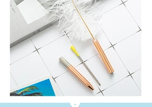Detail showing a white dreamcatcher feather pen with rose gold metal ballpoint pen barrel