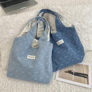 Détail de sacs fourre-tout en denim avec motifs de nœuds blancs et larges bandoulières