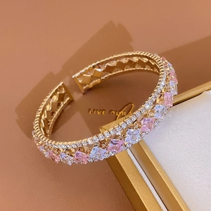 Détail du bracelet doré avec double rangée de zircons cubiques roses et blancs