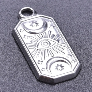 Macro shot of silver octagonal stainless steel evil eye pendant with star and moon engraving