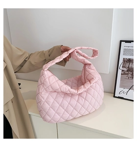 Detailed close-up of a pink quilted nylon tote bag featuring a soft padded puffer design