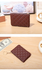 Detail of dark brown quilted faux leather coin purse with golden keychain and zipper