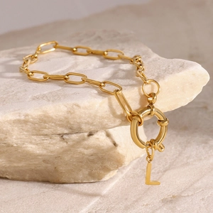 Gold stainless steel link chain bracelet with round letter L pendant on a natural stone base