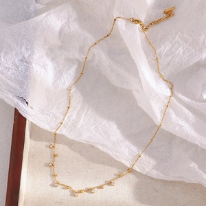 Gros plan d'un collier en perles plaqué or 18 carats avec pendentifs en zircone sur papier
