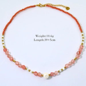 Detail shot of beaded necklace with orange, pink, and white pearls on white background