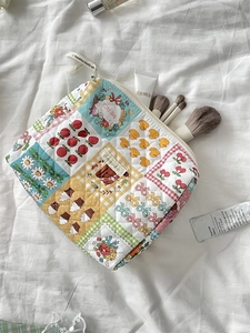 Flat lay of a floral patchwork quilted cosmetic bag with cute strawberry duck patterns