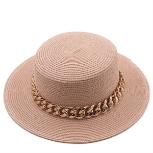 Detail of light pink flat top straw hat featuring a stylish chunky gold metal chain decoration