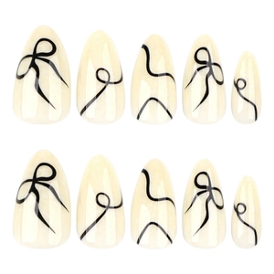 Minimalist almond press-on nails with cream base and black abstract bow-line art patterns