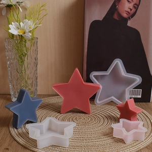 Tre stampi in silicone a forma di stella per candele fai-da-te su un tappeto intrecciato