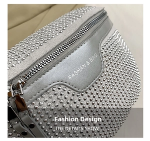 Close-up of sparkling rhinestone surface with metal zipper on stylish silver hobo bag